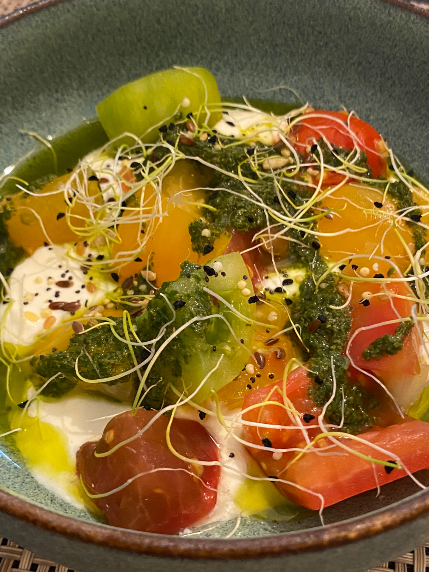 Heirloom tomato and burrata salad with herb pesto and sprouts