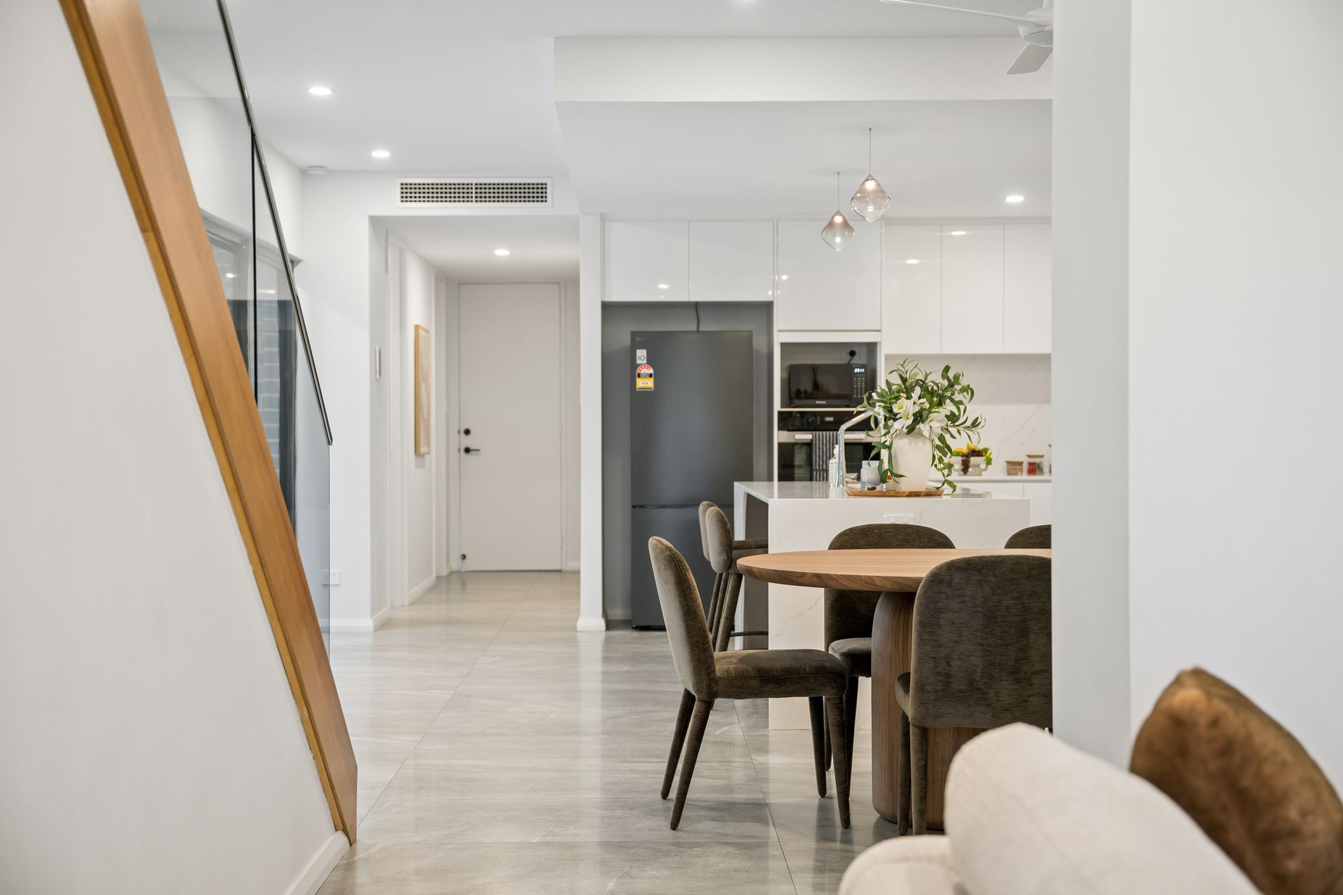 Hallway view through to a furnished kitchen and dining setting