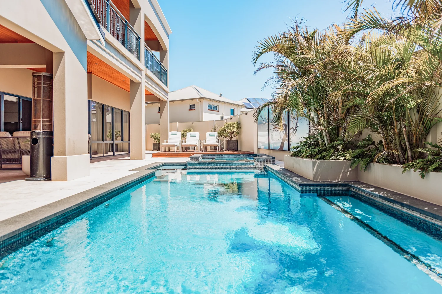 Poolside terrace with palms at The Iluka Mirage