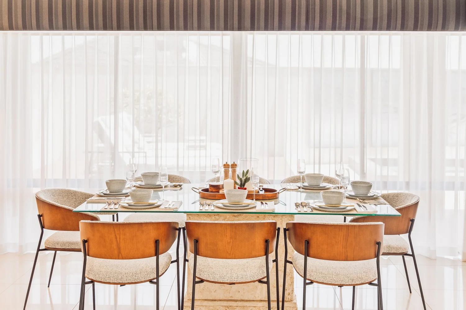 Dining table set for eight in sunlit interiors