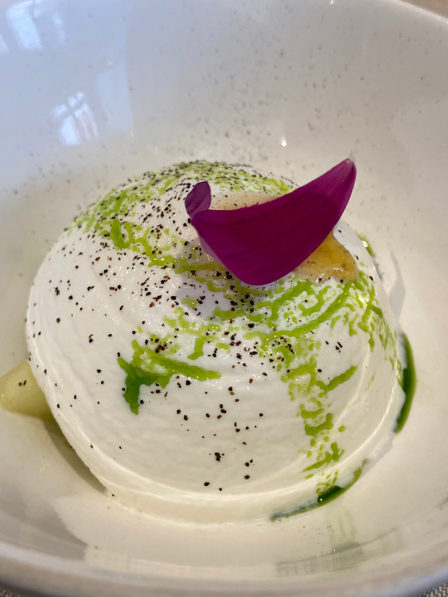 Whipped burrata with cracked pepper, herb oil and petal garnish